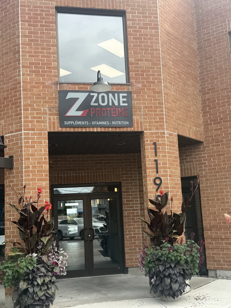 L’entrée de Zone Protéine dans un bâtiment de brique, sous l’enseigne de la boutique.