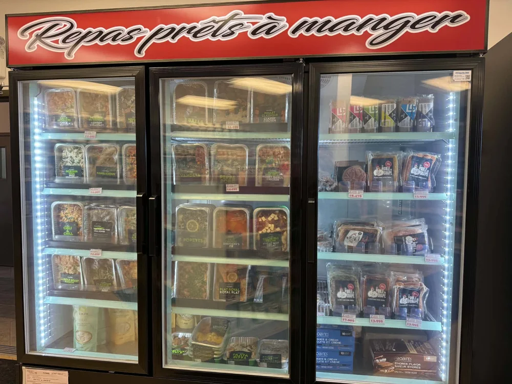 Les réfrigérateurs de la boutique, avec des repas prêts à manger sur les tablettes.